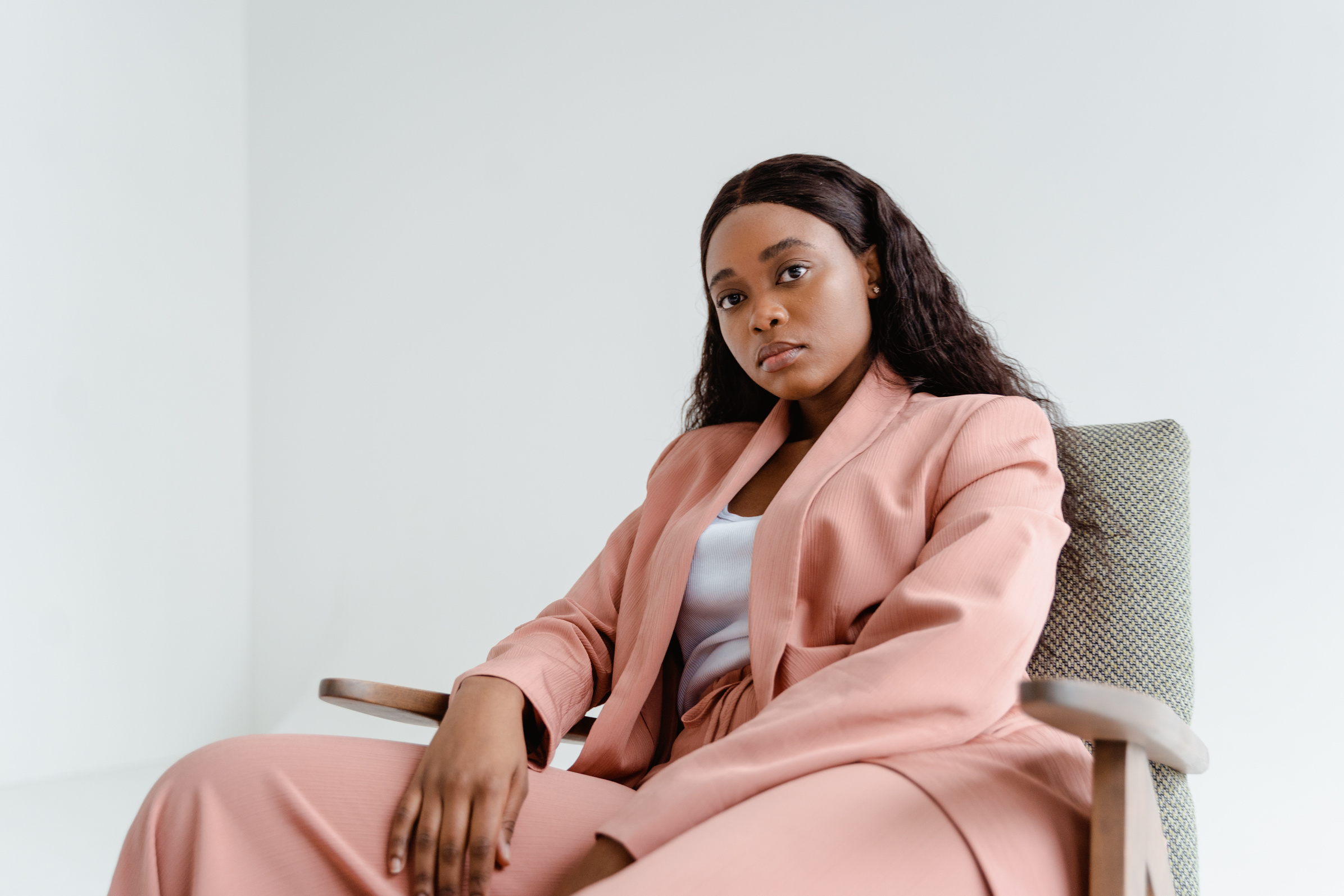 A Woman in Pink Blazer Sitting on a Chair